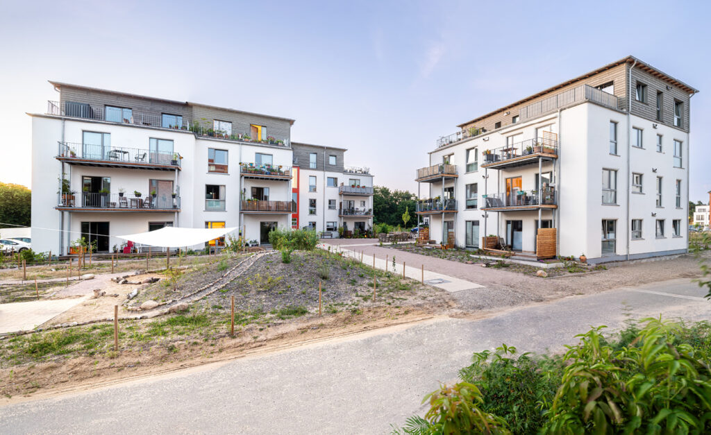 So geht klimafreundlicher Neubau: Wohnanlage querbeet; viergeschossig in Holz, Lehm und Stroh im Lüneburger Hanseviertel auf dem Gelände der ehemaligen Schlieffen-Kaserne, deren Bestand teilweise umgenutzt wurde.