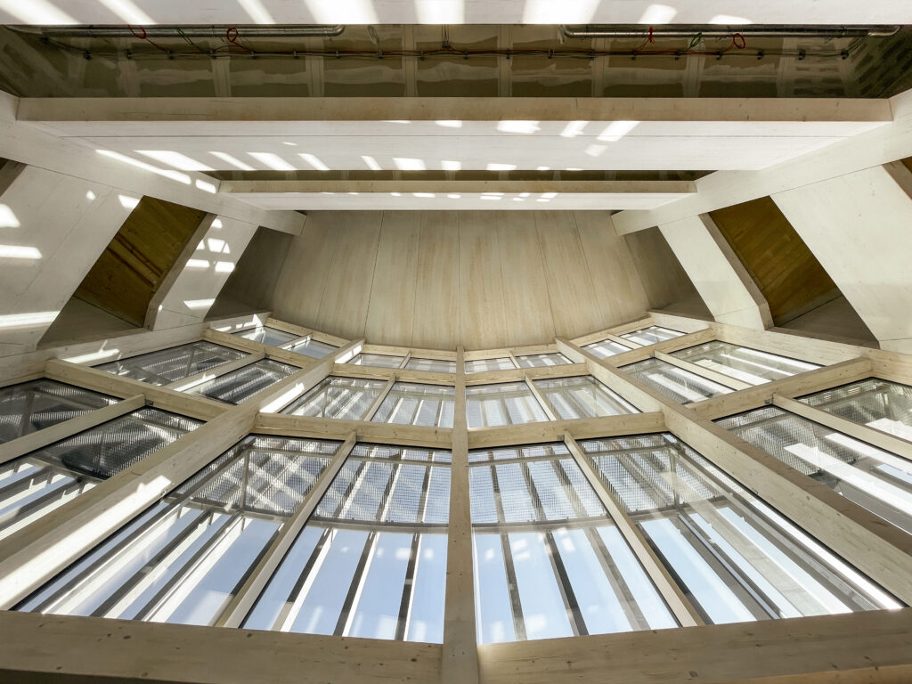 
Bild 4 Blick in den Luftraum im Eingangsbereich mit den beidseitig angeordneten Treppenhäusern in Holzbauweise 
Quelle: Kaden+