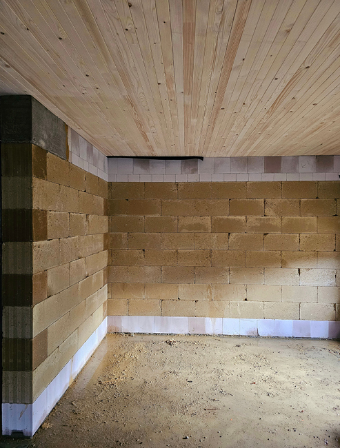Bild 5 Tragende Lehmsteinwände mit Havarieschutz in der unteren Steinlage in Form eines Kalksandvollsteins, kombiniert mit einer Brettstapeldecke im Wohnungsbau (Quelle: Mendler)