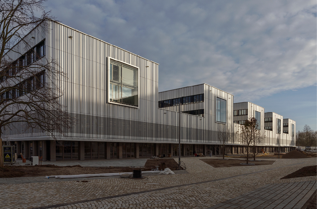 Bild 6130 m langes Lehrgebäude mit Campusabschluss nach Norden, transparentem Erdgeschoss und aufgelockerten Pavillons zum Parkweg (Quelle: PRIMUS developments)