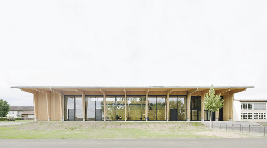 Bild 7 Mehrzweckhalle Ingerkingen, a) Ansicht Südfassade, b) Nordwestansicht (Foto: Brigida González)